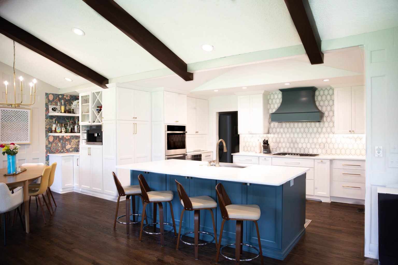 Blue island with white countertop and bar stools installed by kitchen remodeler in Ottawa Hills