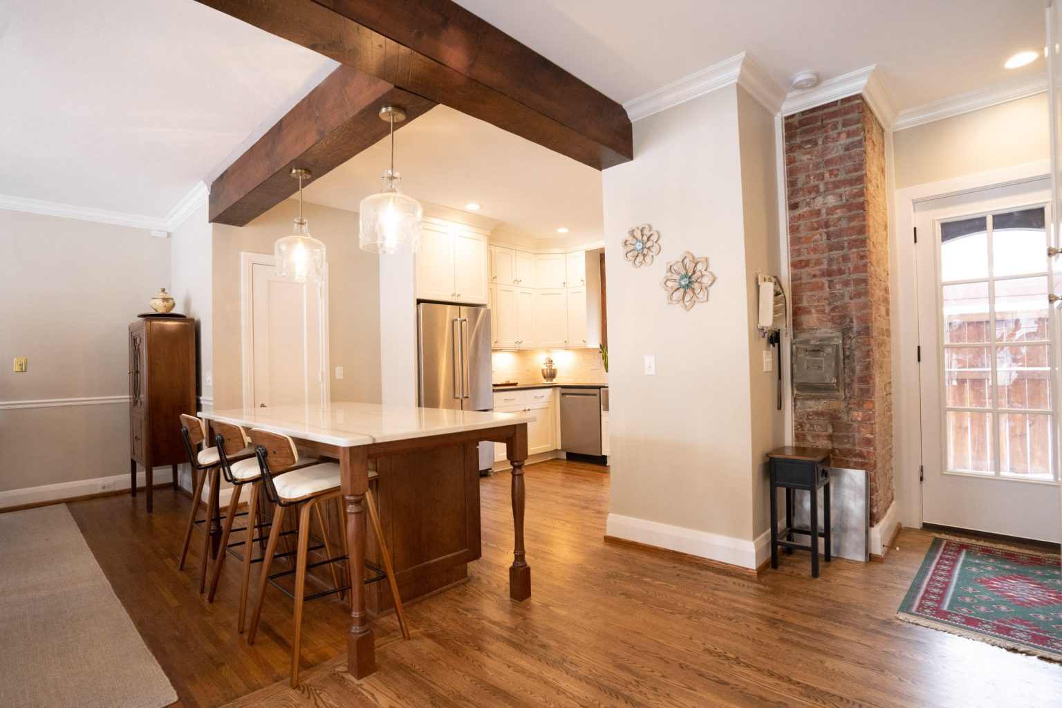 Open-concept kitchen with exposed wood beam installed by Old Orchard kitchen remodeler